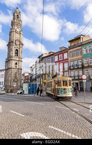 Porto, Portogallo. Il vecchio tram passa dalla Torre Clerigos, uno dei punti di riferimento e simboli della città. Foto Stock