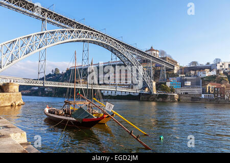 L'iconico Rabelo barche, il tradizionale vino di Porto trasporti, con il quartiere Ribeira e il Dom Luis I Bridge Foto Stock