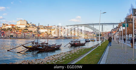 L'iconico Rabelo barche, il tradizionale vino di Porto trasporti, con il quartiere Ribeira e il Dom Luis I Bridge Foto Stock