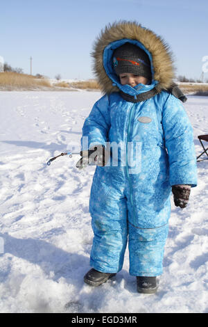 4 anno vecchio ragazzo sulla pesca invernale Foto Stock