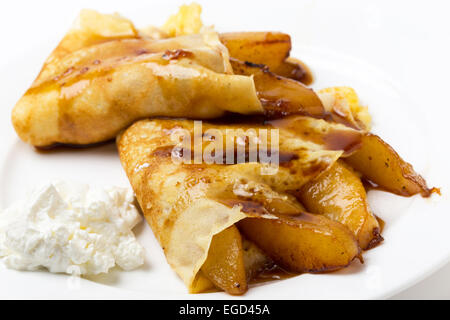 In stile inglese frittelle ripiene con pere caramellate, guarnita con leggera salsa di caramello e servita con yogurt. Foto Stock