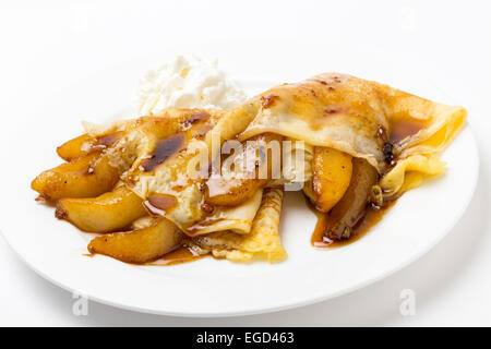 In stile inglese frittelle ripiene con pere caramellate, guarnita con leggera salsa di caramello e servita con yogurt. Foto Stock