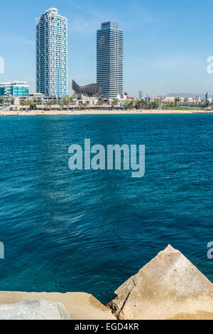 Barceloneta Beach con hotel arts, Torre Mapfre, diversi ristoranti, il pesciolino di Frank Gehry con vari nuotatori. Foto Stock