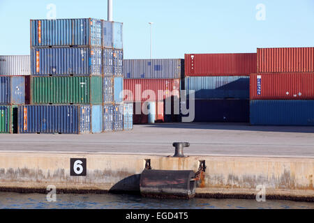 Contrastanti e colorato di pile di contenitori di spedizione ammucchiati uno a Barcellona docks. Foto Stock