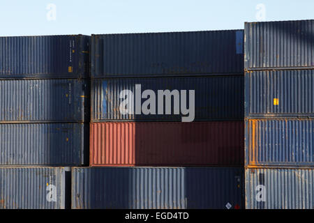 Contrastanti e colorato di pile di contenitori di spedizione ammucchiati uno a Barcellona docks. Foto Stock