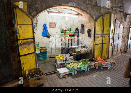 HEBRON, Israele - 10 OTT 2014: un anziano uomo seduto nella sua piccola frutta e fruttivendolo negozio nel centro della città vecchia di Hebron Foto Stock