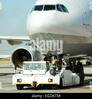 Jet del passeggero trainato da un rimorchiatore al aeroporto di pista di rullaggio Foto Stock