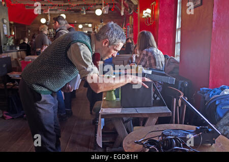 Un collettore di record a un record fair guardando attraverso una scatola di 45 rpm singles Foto Stock