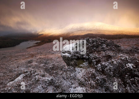 Spettacolare la luce sopra la coperta di neve a nord-ovest di Highlands si affaccia il vertice Beinn Eighe sopra Loch Clair in inverno a sunrise, Torridon, Scotland, Regno Unito Foto Stock