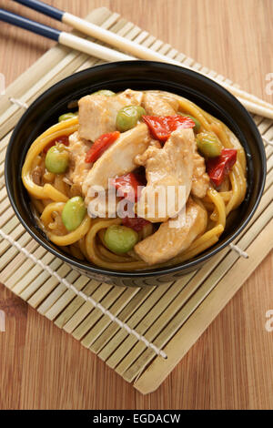 Pollo Teriyaki con noodles edamame e peperoni rossi Foto Stock