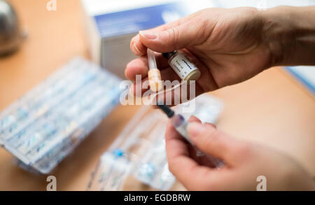 Berlino, Germania. Il 23 febbraio, 2015. Un infermiere può contenere fino un vaccino combinato contro il morbillo, rosolia e parotite in un ambulatorio medico a Berlino, Germania, 23 febbraio 2015. Dopo la somministrazione del vaccino, il sistema immunitario si accumula gli anticorpi contro il virus. Questi anticorpi proteggere contro le infezioni causate da questi virus. Foto: BERND VON JURTCZENKA/dpa/Alamy Live News Foto Stock