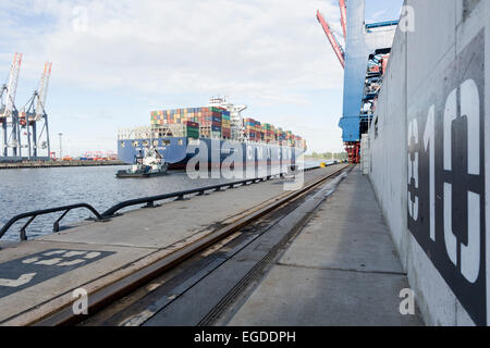 Le navi portacontainer trainato per l ormeggio nel porto, Burchardkai, Amburgo, Germania Foto Stock