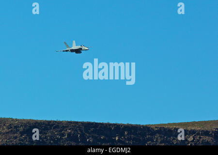 Vista in lontananza un US Navy F/A-18F Super Hornet jet fighter, immettendo Rainbow Canyon. Foto Stock