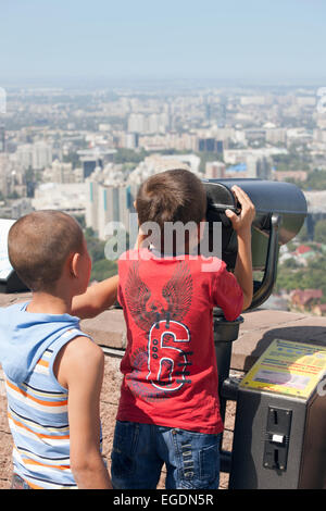 Ragazzi cercando in vista di Almaty da Kok Tobe mountain, Almaty, Kazakhstan Foto Stock