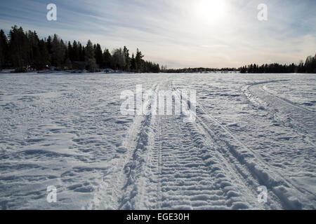 Tracce di motoslitte sul lago ghiacciato Foto Stock