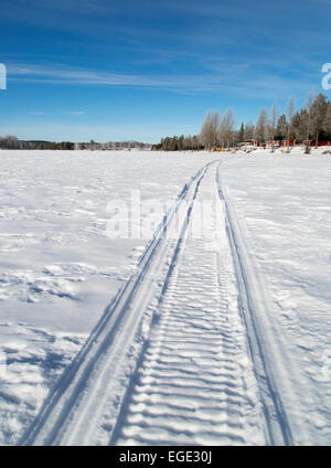 Tracce di motoslitte sul lago ghiacciato Foto Stock