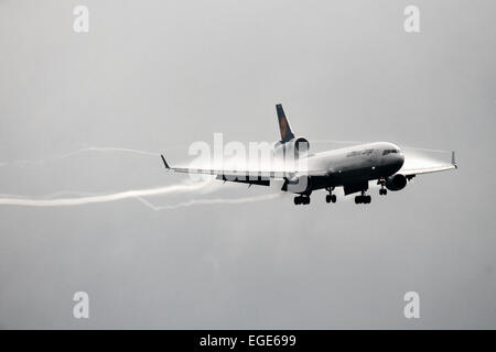 Lufthansa Cargo McDonnell Douglas MD-11 si avvicina la pista 23R all'aeroporto di Manchester, lasciando una scia di vortex & vapore dietro. Foto Stock