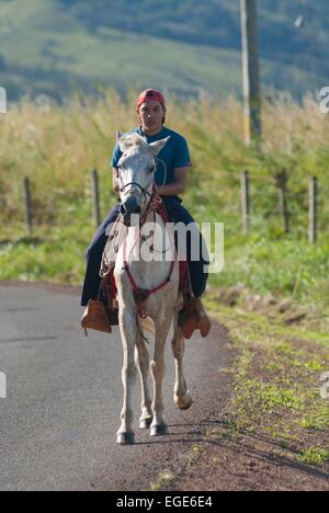 Costa Rica.Tilaran, cavallo ciclista su strada // Costa Rica. Tilaran, cavalier sur la route Foto Stock