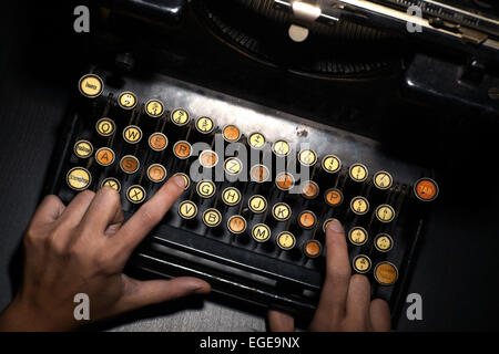 Colore dettaglio orizzontale della tastiera di una vecchia macchina da scrivere e di due mani. Foto Stock