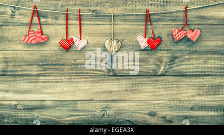 Cuori rossi su sfondo di legno. Il giorno di San Valentino la decorazione. In stile vintage immagine filtrata Foto Stock