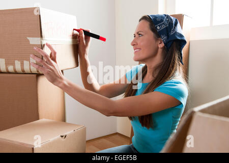 Giovane donna di scatole di imballaggio Foto Stock