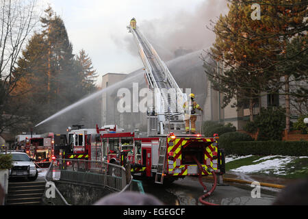 Coquitlam, BC, Canada - 16 Febbraio 2015 : Firefighter equipaggi combattendo complesso di appartamenti il fuoco sul Glen drive in Coquitlam. Foto Stock