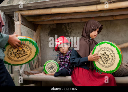 Un gruppo di bambini rurali che giocano a Rebana, mentre si stanno allenando per una performance musicale islamica a Buni, Bekasi , Giava Occidentale, Indonesia. Foto Stock