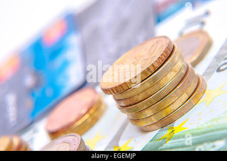 Una torre di monete in euro, banconote, moneta europea Foto Stock