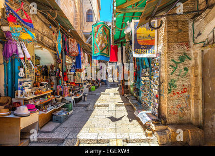 Strette strade di pietra tra bancarelle con souvenir tradizionali e dei beni al bazaar a Gerusalemme. Foto Stock