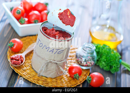 Salsa di pomodoro in banca di metallo e su un tavolo Foto Stock