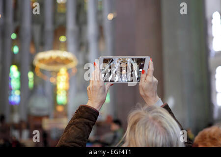 Donna foto video interno della Sagrada Familia di Barcellona, utilizzando un tablet iPad tipo dispositivo. Vivendo il mondo in modo digitale Foto Stock