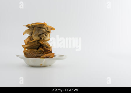 La procrastinazione - stack di usato teabags colorate in un sacchetto da tè titolare con spazio di copia Foto Stock