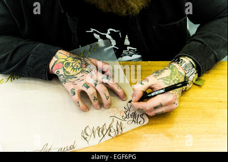 Un tattooist lavorando su un progetto al Brighton Tattoo Convention. Foto Stock