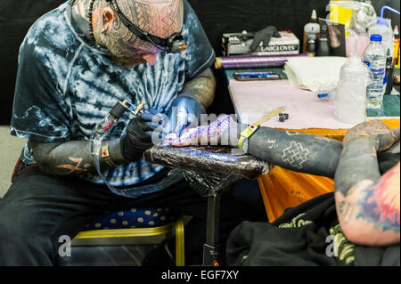 Un uomo tatuato sul palmo della sua mano al Brighton Tattoo Convention. Foto Stock