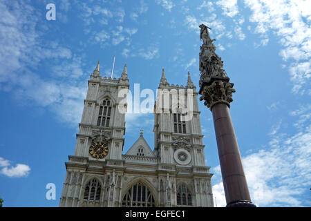 Vista di Westminster Abbey, il London che mostra i dettagli architettonici contro un cielo azzurro con soffici nuvole bianche Foto Stock