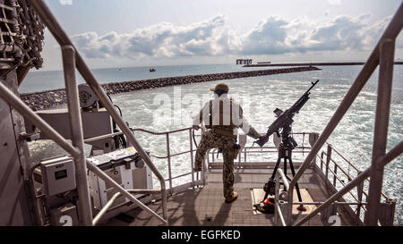 Un marinaio ci sta di guardia come i militari Sealift il comando congiunto del ad alta velocità a nave USNS Spearhead tira in porto come parte dell Africa per il diritto marittimo esecuzione Partnership Febbraio 14, 2015 in Sekondi, Ghana. Foto Stock