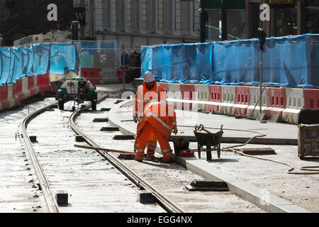 Birmingham, West Midlands, Regno Unito. Il 24 febbraio, 2015. Operai laici tracce in Corporation Street come parte del centro città estensione del Midland Metro Tram. Questa fase di estensione, tra Snow Hill e la nuova strada stazioni ferroviarie, è dovuto per essere poi completato nel 2015. Ulteriori estensioni a Birmingham Town Hall e Centenary Square sono previste per il completamento nel 2017. Credito: Colin Underhill/Alamy Live News Foto Stock