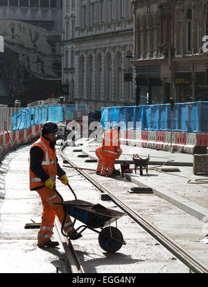 Birmingham, West Midlands, Regno Unito. Il 24 febbraio, 2015. Operai laici tracce in Corporation Street come parte del centro città estensione del Midland Metro Tram. Questa fase di estensione, tra Snow Hill e la nuova strada stazioni ferroviarie, è dovuto per essere poi completato nel 2015. Ulteriori estensioni a Birmingham Town Hall e Centenary Square sono previste per il completamento nel 2017. Credito: Colin Underhill/Alamy Live News Foto Stock