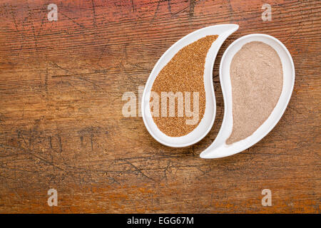 Senza glutine teff grano e farina in forma di lacrima bocce contro legno grunge Foto Stock