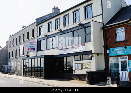 L'ex strada costiera Hotel, Carrickfergus, che è stato giacenti abbandonati e rimasti invenduti per quasi dieci anni accanto a un appartamento incompiuta di blocco Foto Stock