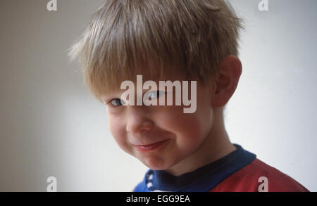 Toddler sorrisi maschio fa il broncio alla fotocamera Foto Stock