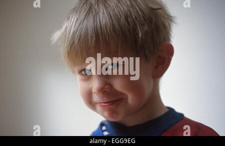 Toddler sorrisi maschio fa il broncio alla fotocamera Foto Stock