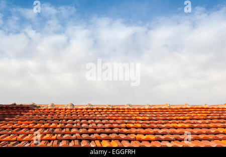 Svuotare la foto di sfondo rosso con tetto in tegole e cielo molto nuvoloso Foto Stock