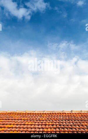 Svuotare la foto di sfondo rosso con tetto in tegole e blu cielo nuvoloso Foto Stock