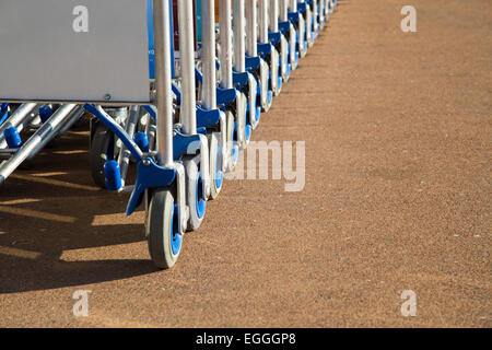 Fila di carrelli per bagagli con uno spazio pubblicitario closeup view Foto Stock