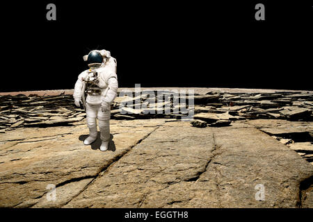 Un astronauta sondaggi la sua situazione dopo essere stata fregata su un pianeta sterile. La quantità di nero dello spazio profondo è lo sfondo. Foto Stock