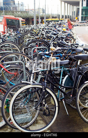 Holland, Amsterdam, biciclette parcheggio nei pressi della stazione centrale verticale Foto Stock