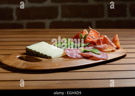 Tapas Scheda Antipasti: Prosciutto Serrano, Salchicon salami, insalata di pomodoro e formaggio Manchego decorate con pisello verde foglie. Foto Stock