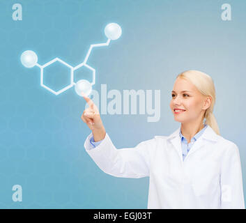 Donna sorridente medico rivolto a molecola Foto Stock