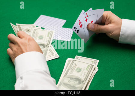 Giocatore di poker con carte e soldi al casino Foto Stock